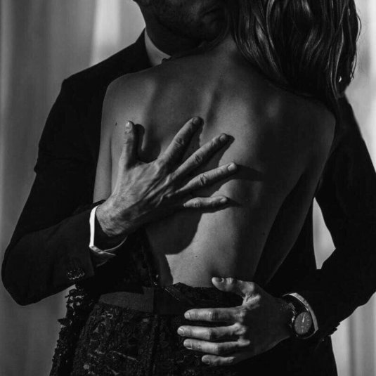 Мужчина расстегивает платье женщине