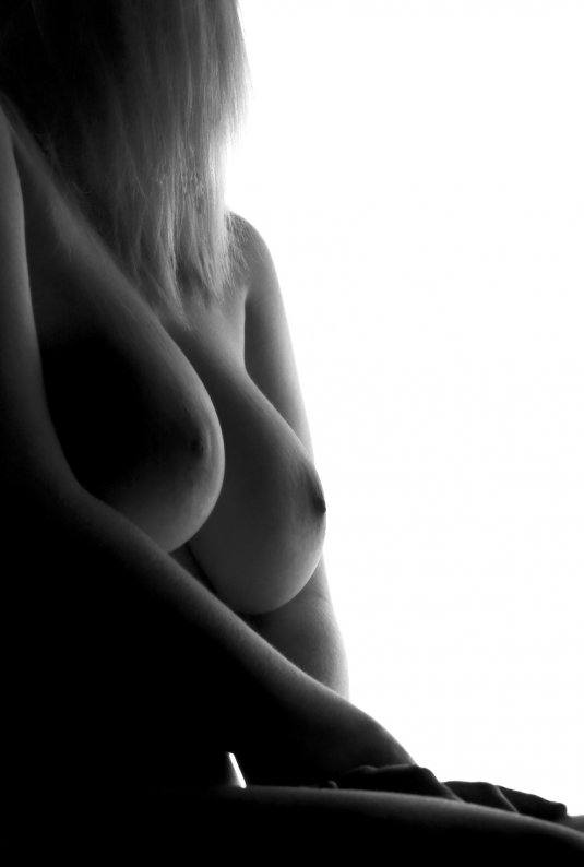 Девушка с большими сиськами лежит на спине