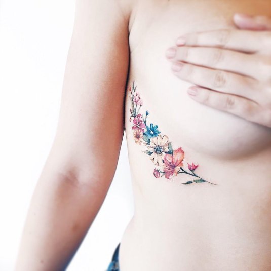 Цветное тату под грудью