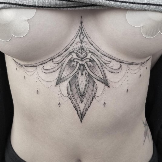 Тату между грудиной у девушек