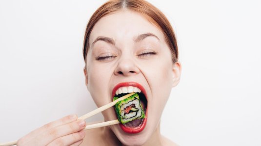 Девушка ест роллы