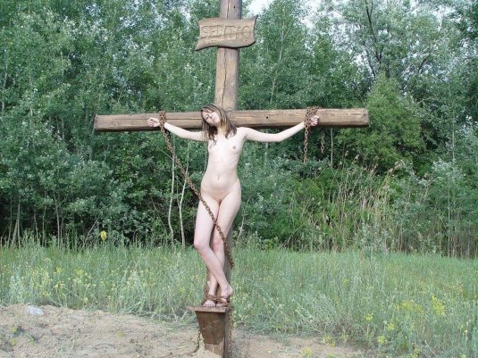 Нагая женщина распята на кресте