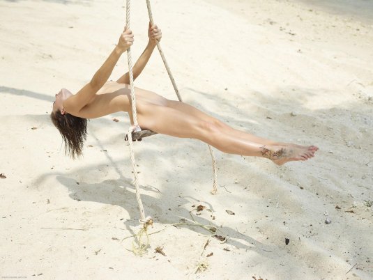 Голая блондинка на качелях