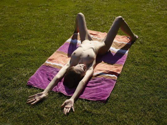 Голая загорает на лужайке